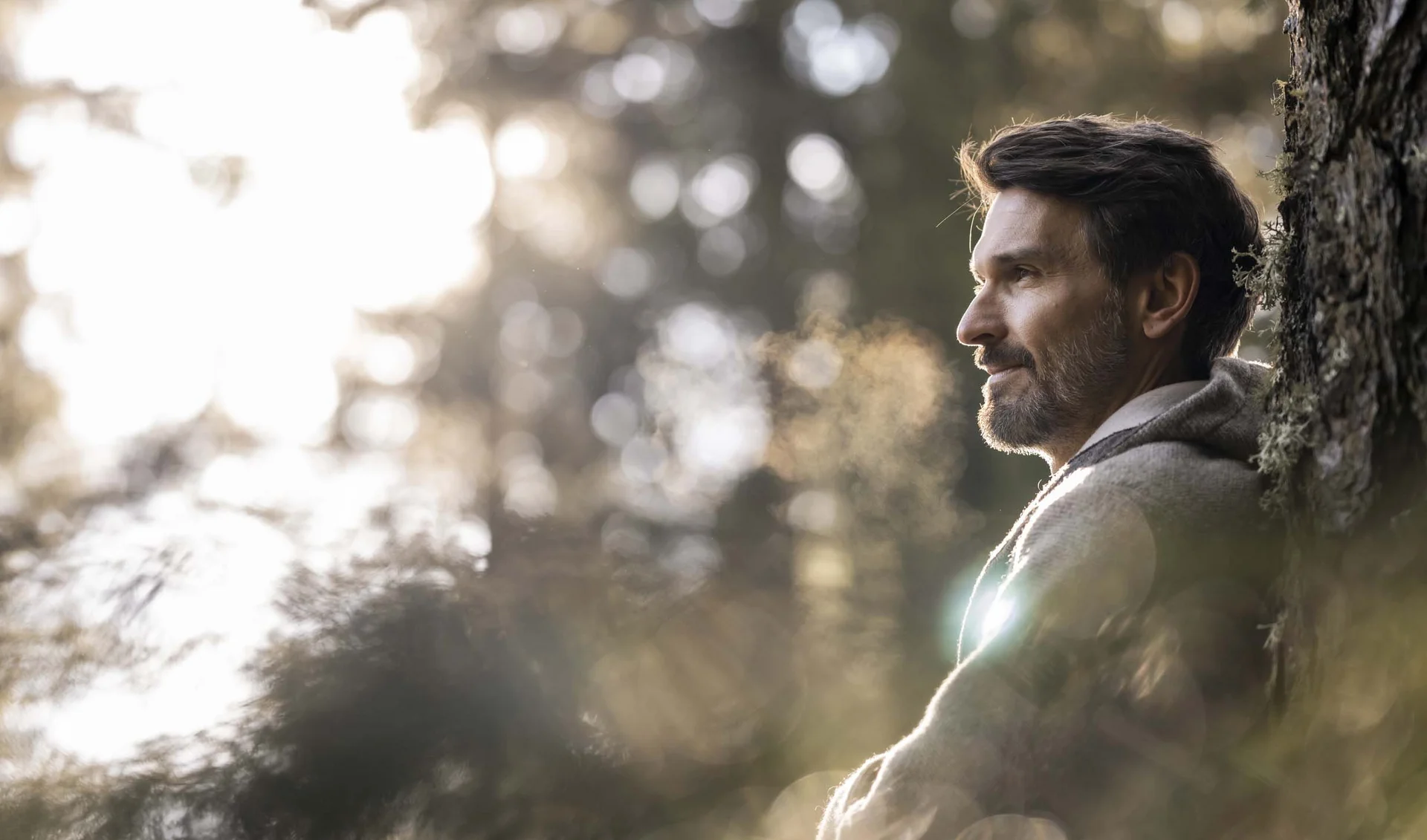 A hideaway for your exclusive holiday in Val Pusteria/Pustertal Man leaning against tree in forest with sunlight filtering through