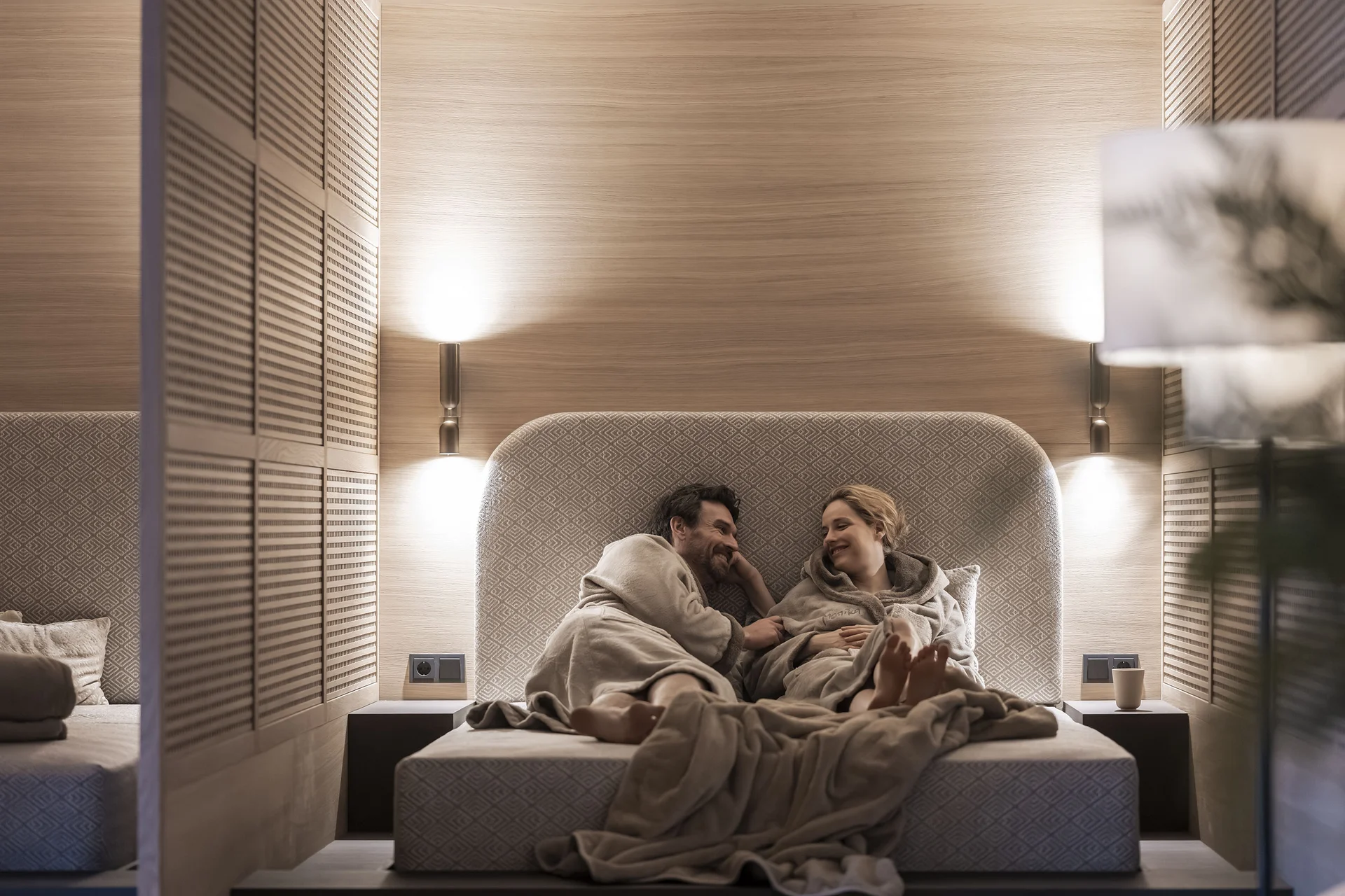 Hotel Monika: das romantische Hotel in Südtirol Paar entspannt in Bademänteln auf einem Bett in einem modernen Schlafzimmer