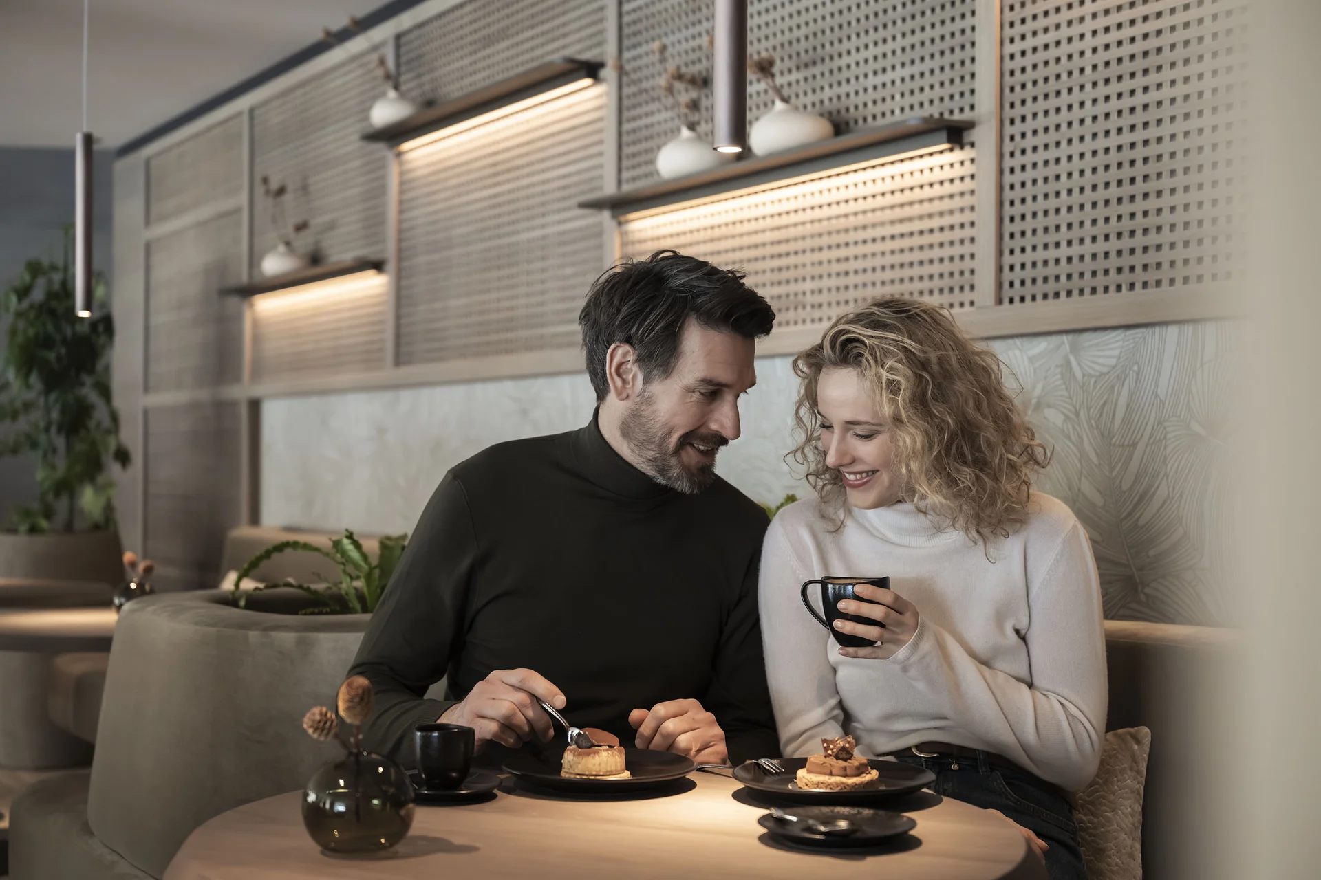 Hotel Monika in Sexten: Wohlbefinden inmitten der Dolomiten Paar genießt Kaffee und Kuchen in gemütlichem Café