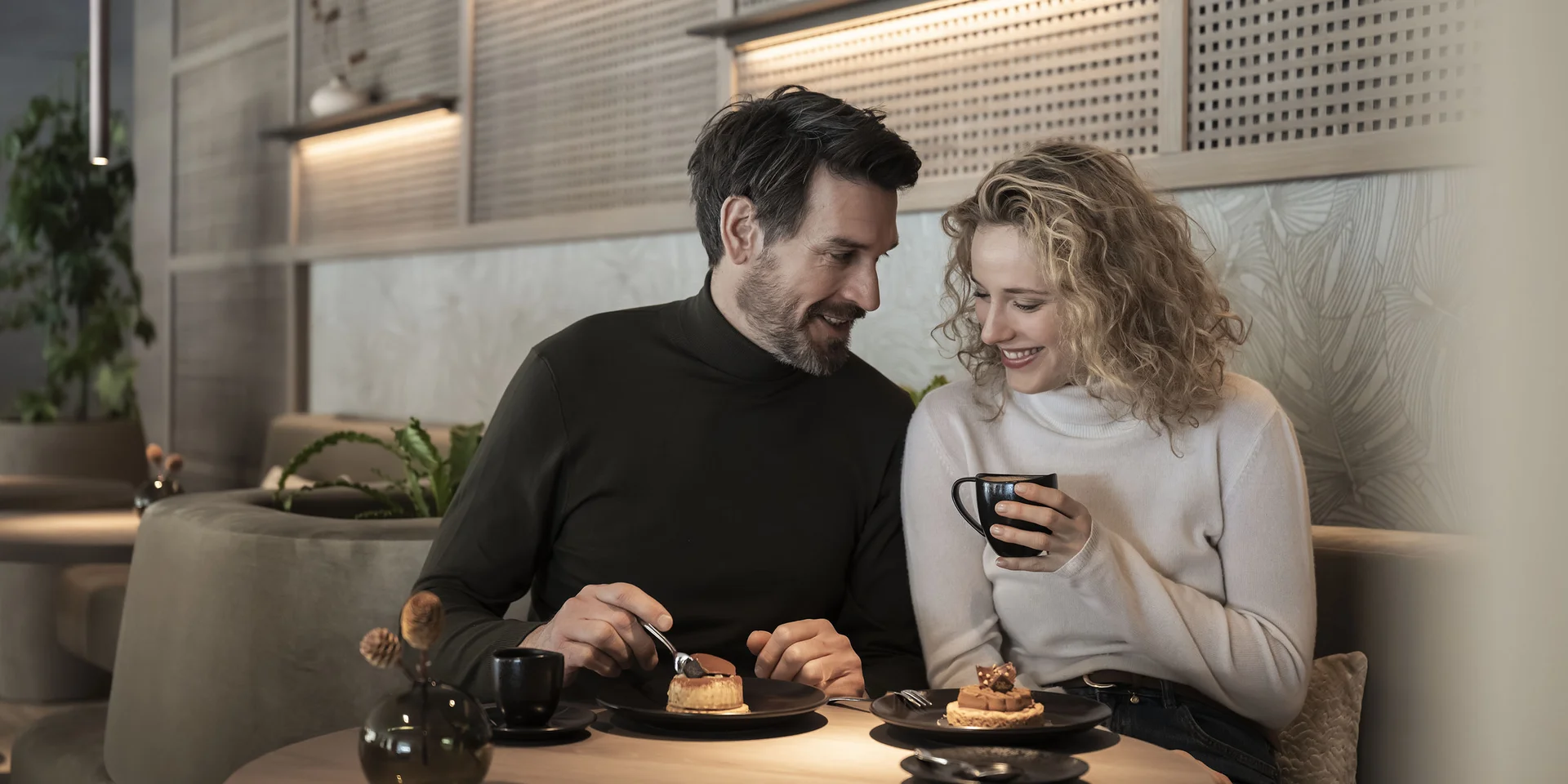 Genuss in neuer Dimension: Ihr Gourmethotel in Südtirol Paar genießt Kaffee und Kuchen in gemütlichem Café