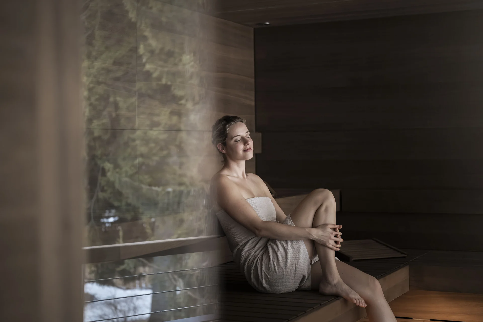 Saunalandschaft Frau entspannt in Sauna mit Handtuch und geschlossenen Augen