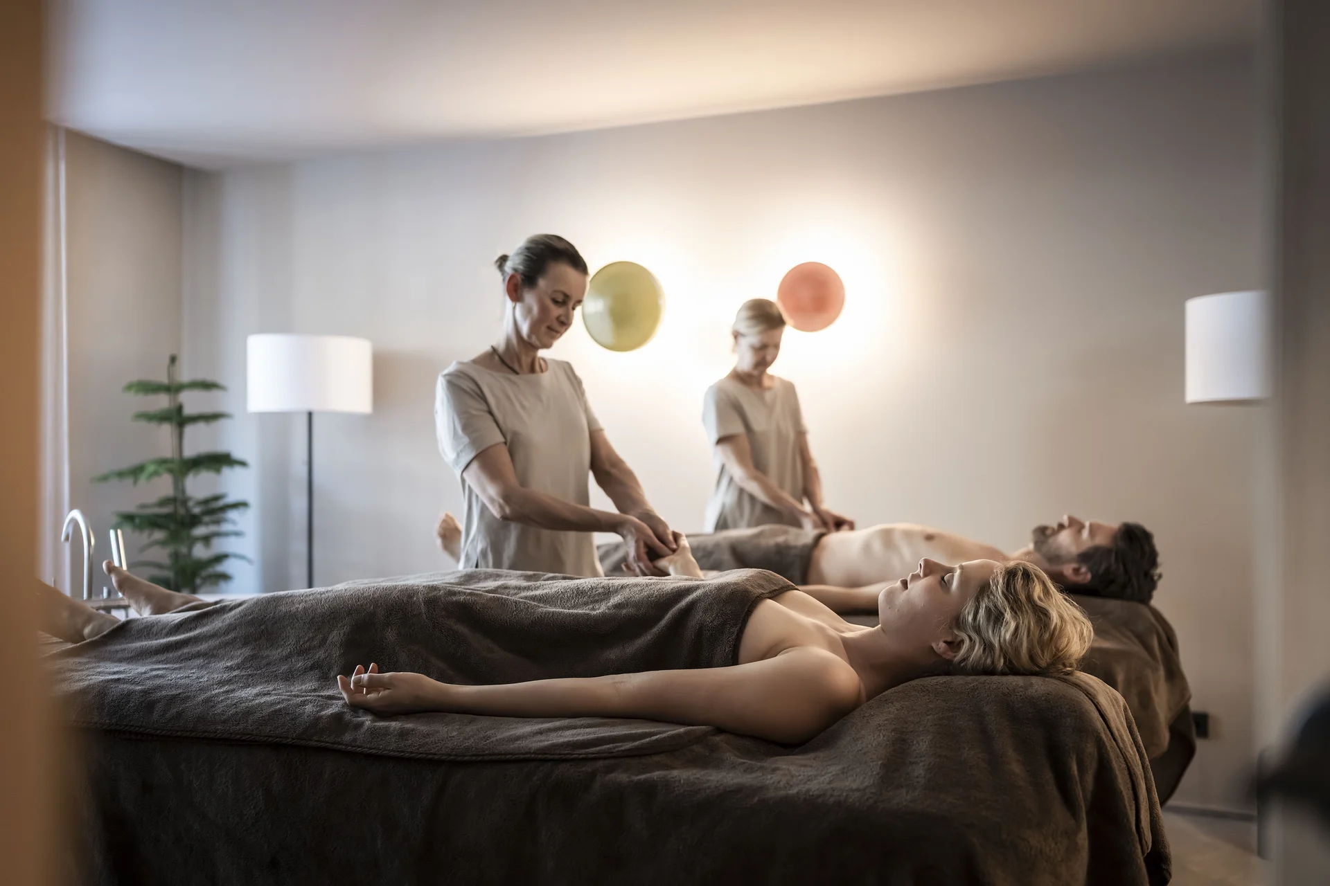 Hotel Monika: wohltuender Day Spa im Pustertal Paar erhält Paarmassage im Spa auf Massageliegen mit braunen Handtüchern
