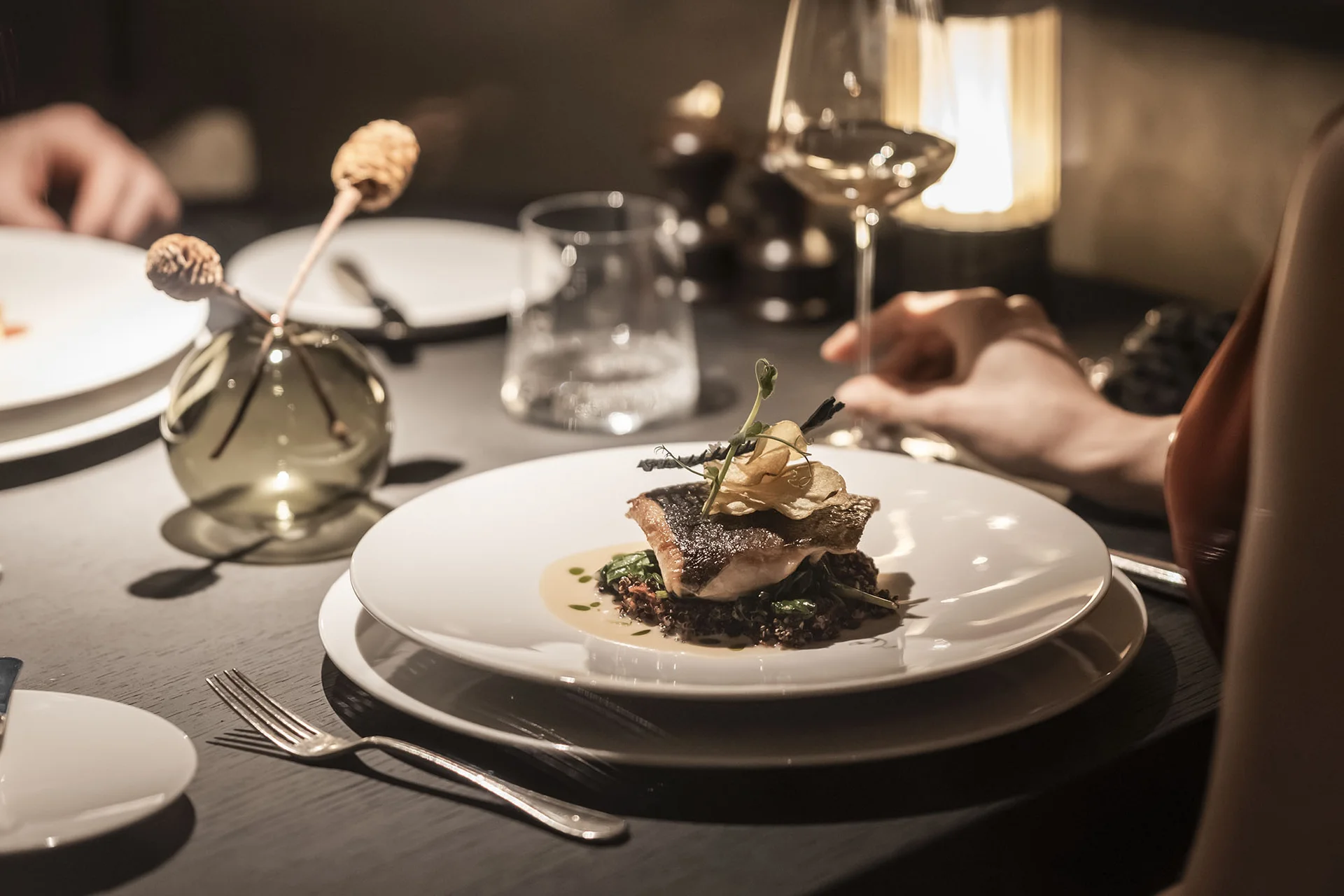 Hotel Monika: Ihr Adults-only-Wellnesshotel in Südtirol Elegantes Abendessen mit Weingläsern und serviertem Gourmetgericht