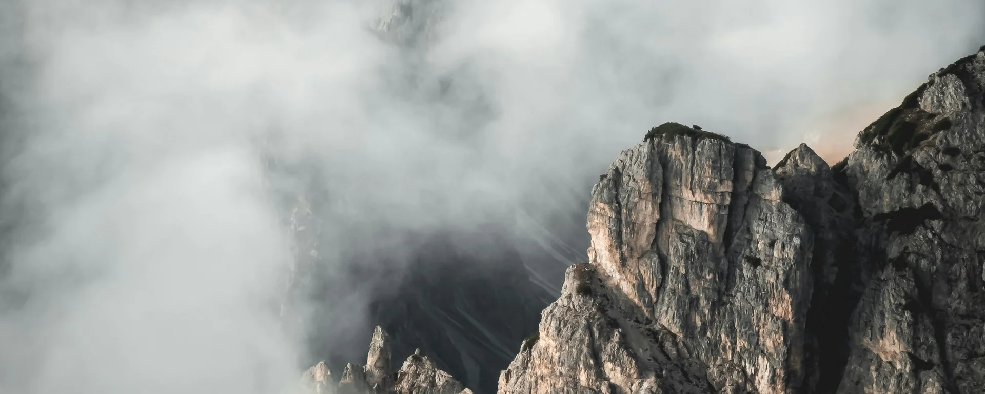 Fitness, yoga, outdoor fun: active hotel in South Tyrol. Rocky mountain peaks surrounded by thick fog