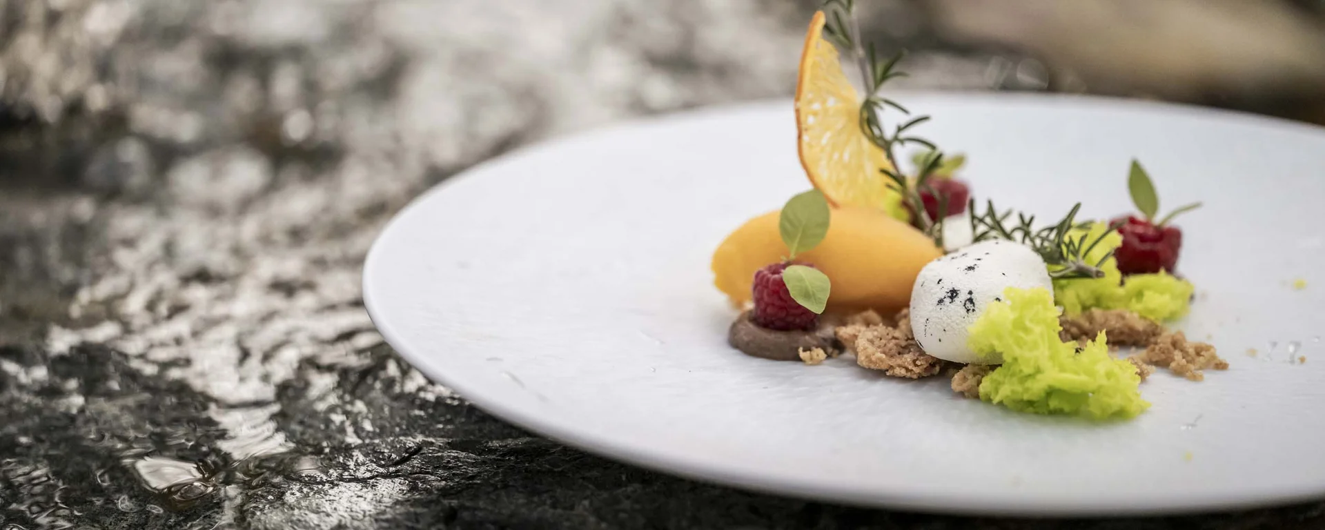 Café the bosco®: a place of delights and encounters Artistic dessert with fruits and herbs on a white plate