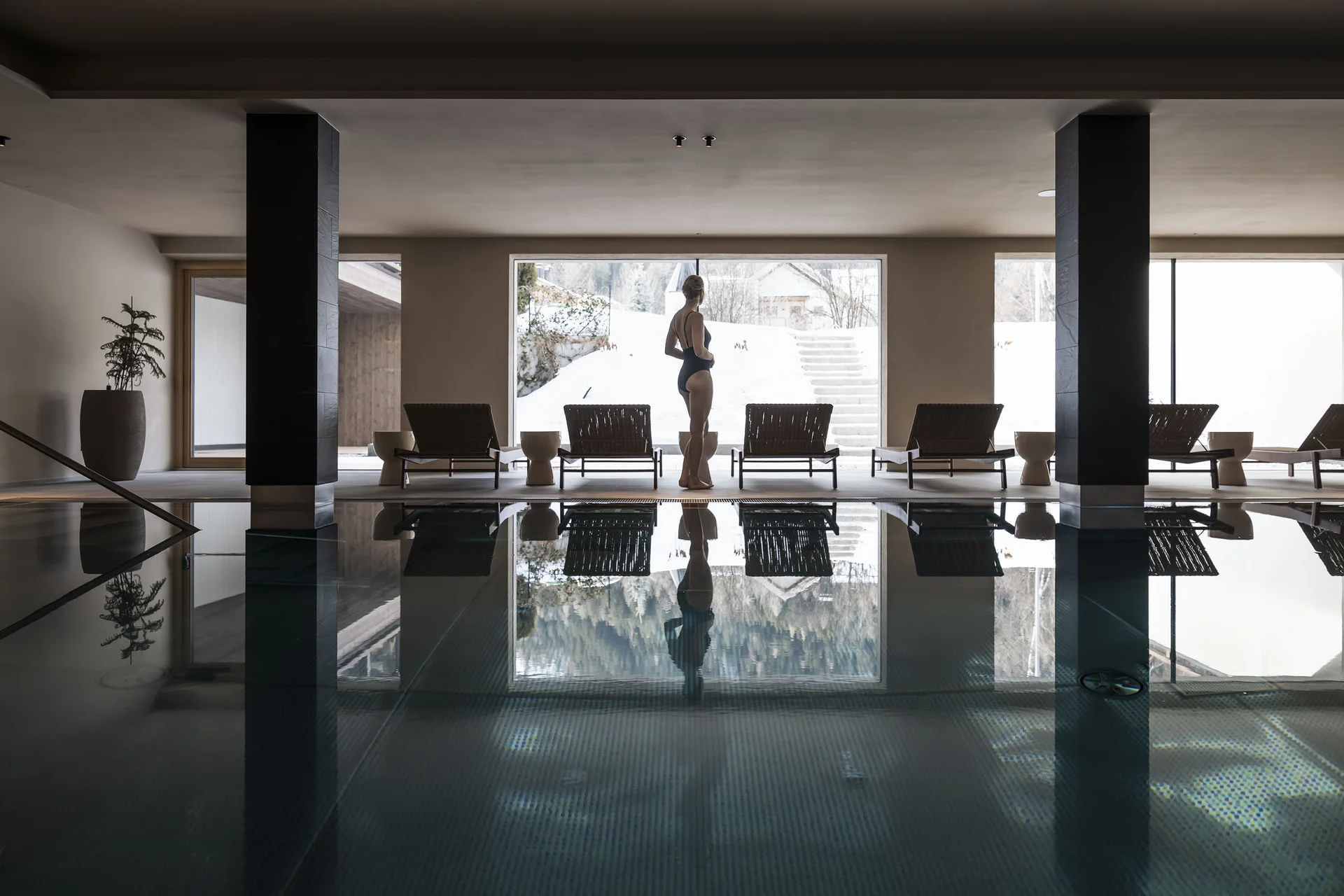 Hotel Monika in Sexten: Wohlbefinden inmitten der Dolomiten Frau am Innenpool mit Schneelandschaft draußen