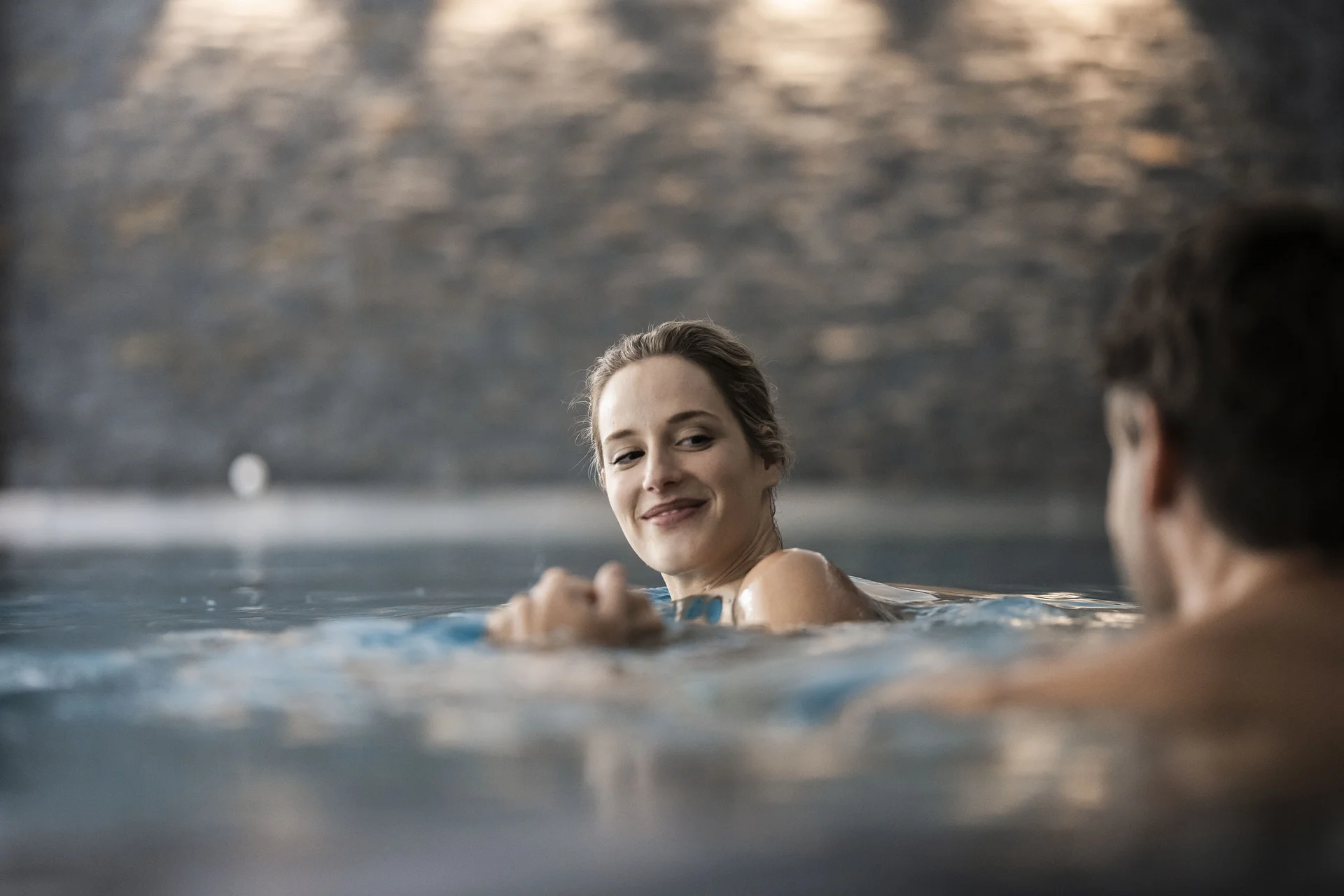 Hotel Monika in den Dolomiten – mit Pools und Spa Area Frau und Mann genießen gemeinsam Zeit in einem Pool