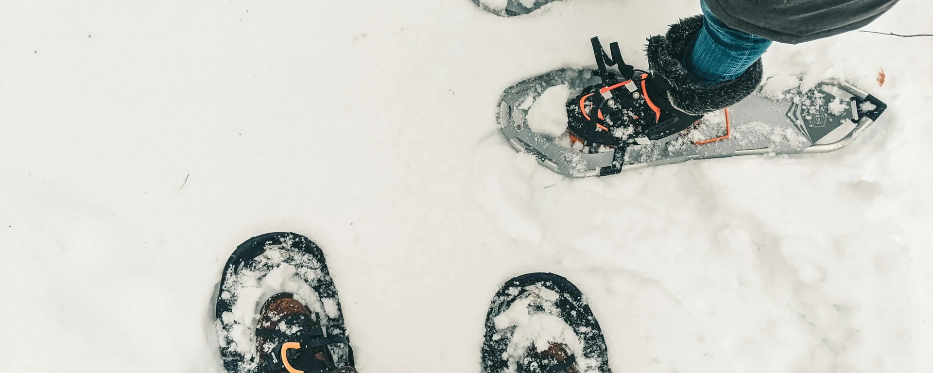 Fitness, yoga, outdoor fun: active hotel in South Tyrol. Two people wearing snowshoes standing on snow