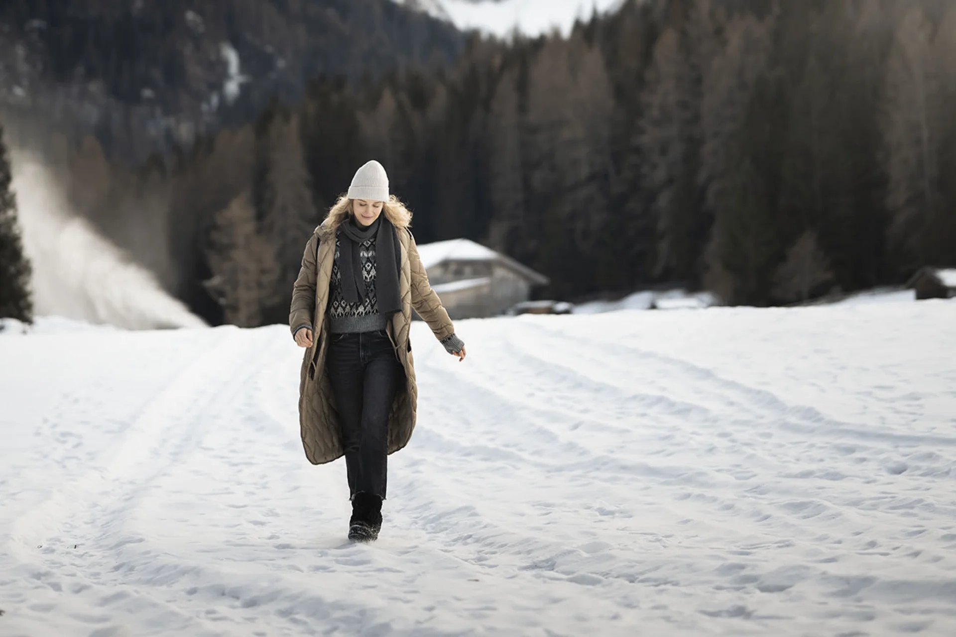 Luxus aus der Natur: Ihr nachhaltiges Hotel in Südtirol Frau in Winterkleidung geht auf schneebedecktem Feld mit Bergen im Hintergrund