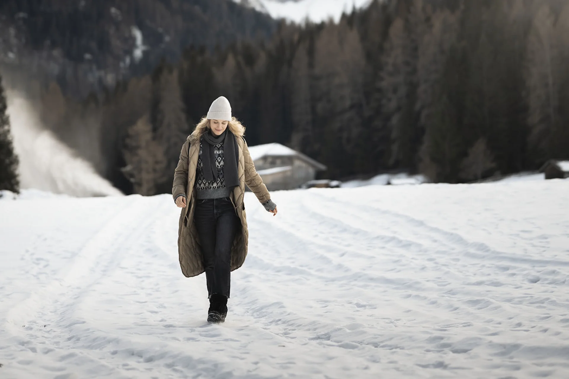 Winterurlaub, der bereichert – im Skihotel in den Dolomiten Frau in Winterkleidung geht auf schneebedecktem Feld mit Bergen im Hintergrund