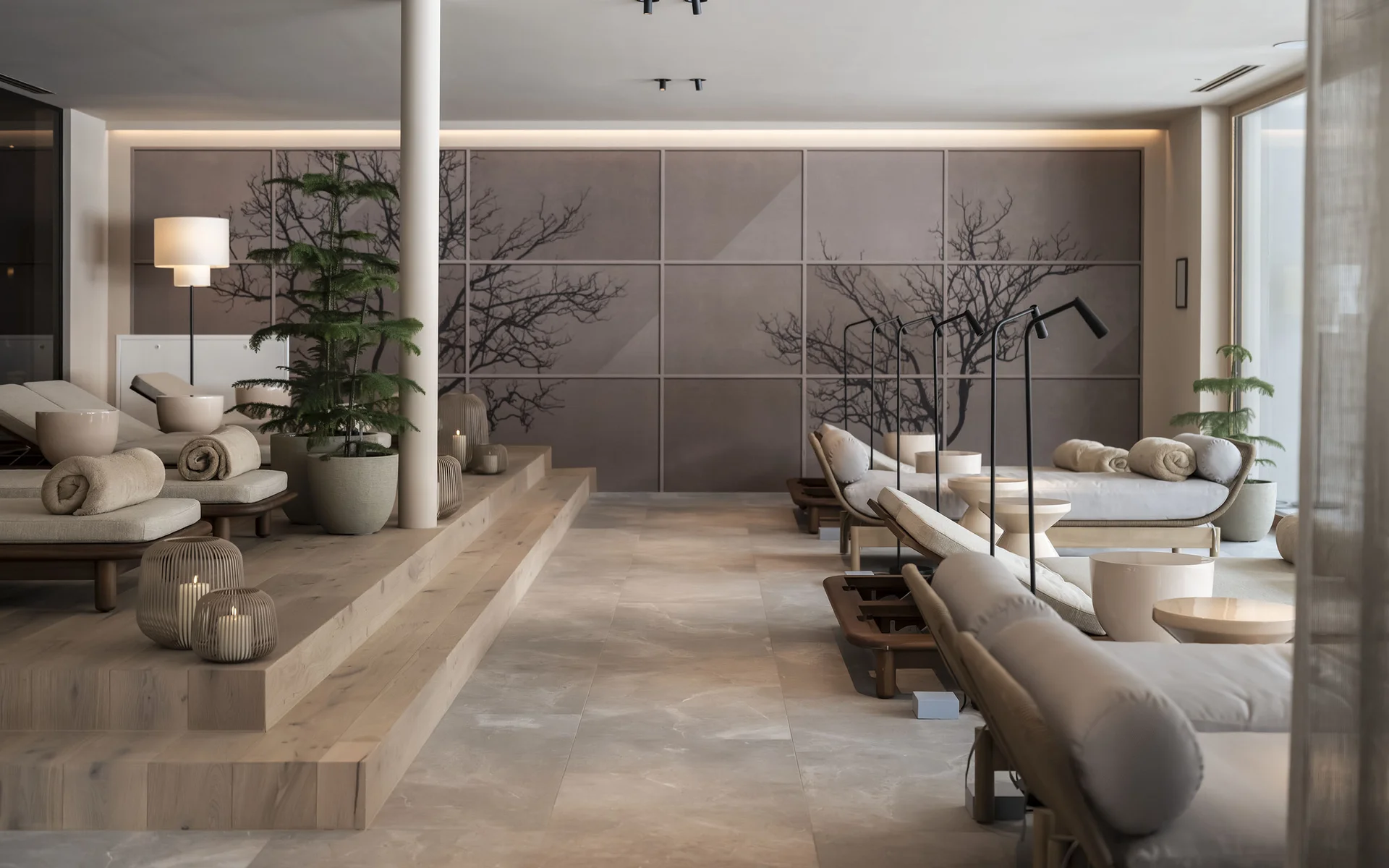 Wohlbefinden in neuer Dimension: Ihr Wellnesshotel in Sexten Moderner Wellnessbereich mit Liegen, Pflanzen und Kerzen