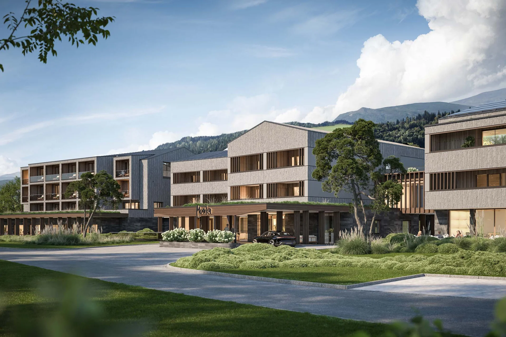 Hotel Monika in Sexten: Wohlbefinden inmitten der Dolomiten Modernes Hotelgebäude umgeben von Grünflächen und Bergen im Hintergrund