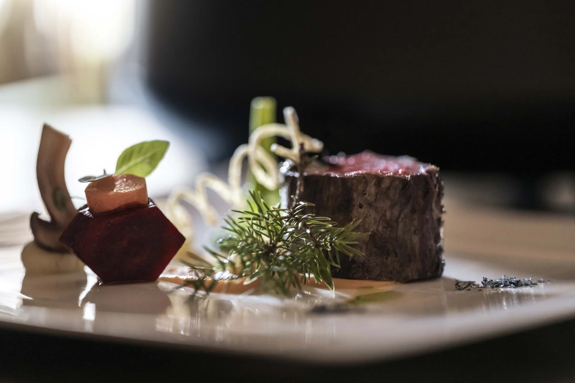 CANA à la carte restaurant in Sexten Gourmet dish with beef, vegetables, and herbs elegantly plated