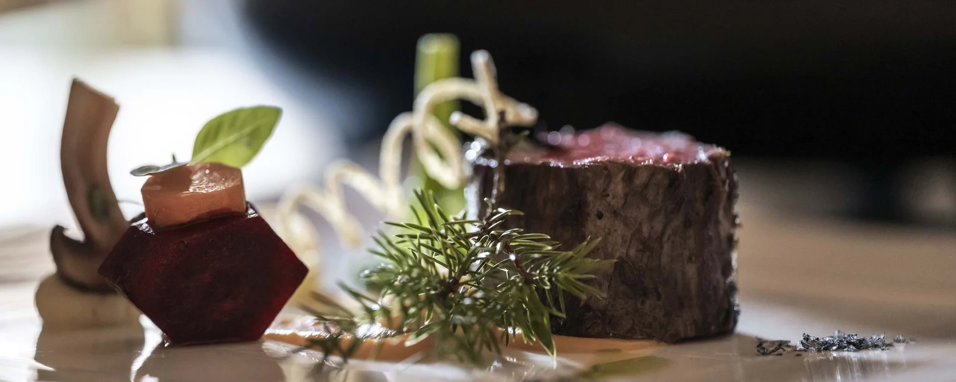 CANA à la carte restaurant in Sexten Gourmet dish with beef, vegetables, and herbs elegantly plated