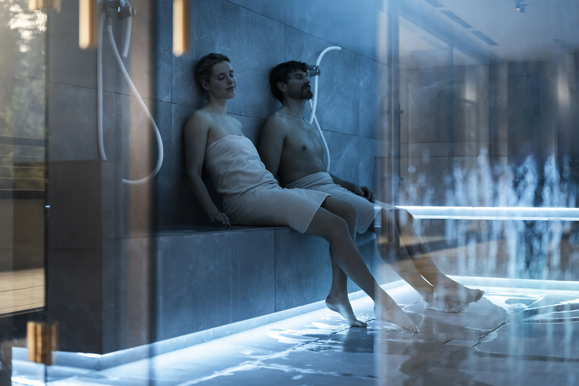 Saunalandschaft Paar entspannt in einem modernen Dampfbad mit Handtüchern