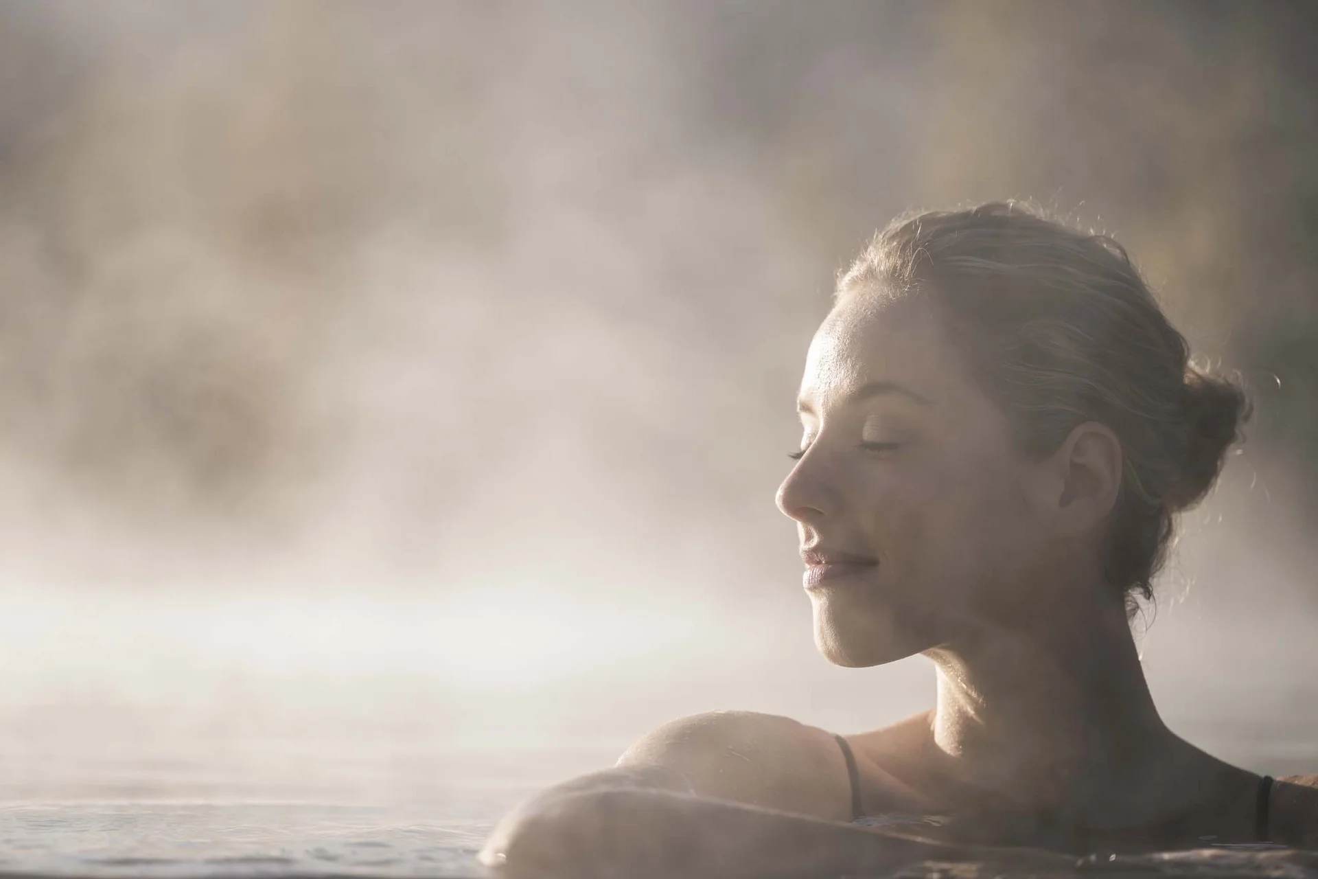 Hotel Monika in Sexten: Wohlbefinden inmitten der Dolomiten Frau entspannt im heißen Thermalwasser mit geschlossenen Augen