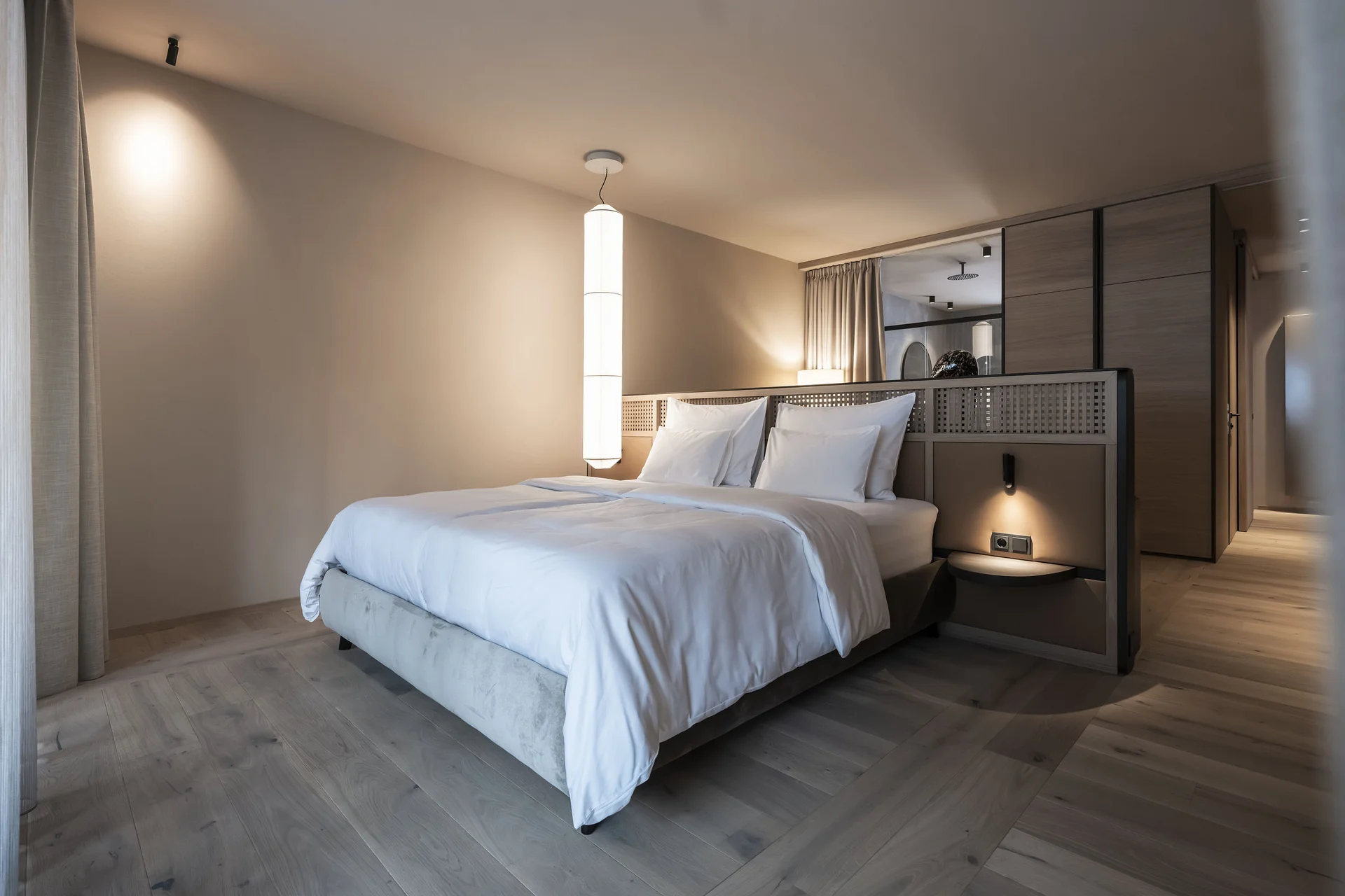 Hotel Monika in Sexten: Wohlbefinden inmitten der Dolomiten Modernes Schlafzimmer mit großem Bett und sanfter Beleuchtung