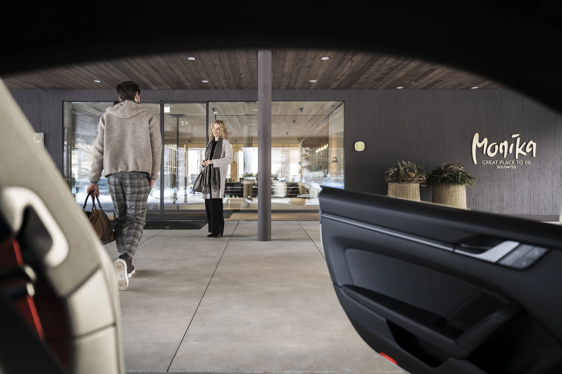 Hotel Monika in Sexten: Wohlbefinden inmitten der Dolomiten Person geht zum Eingang eines modernen Gebäudes mit Monika Schriftzug