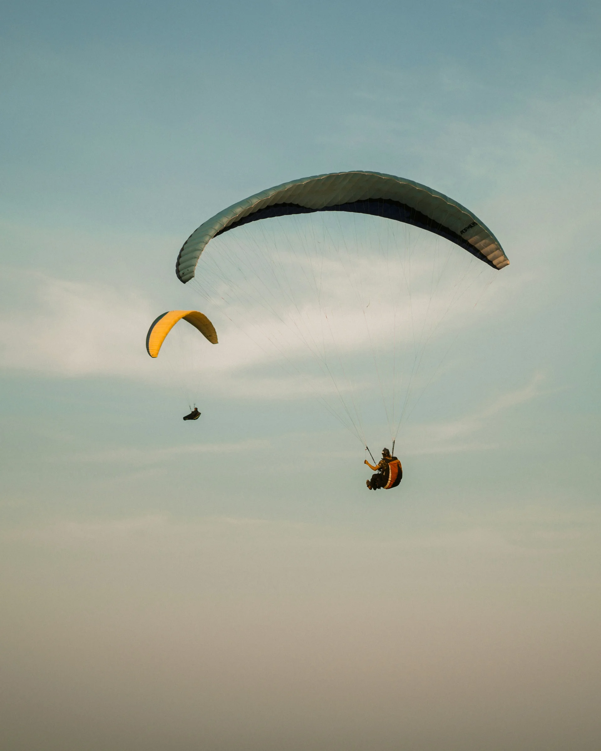 Summer in the mountains. At your hiking hotel in the Dolomites. Two paragliders flying in the sky at dusk.