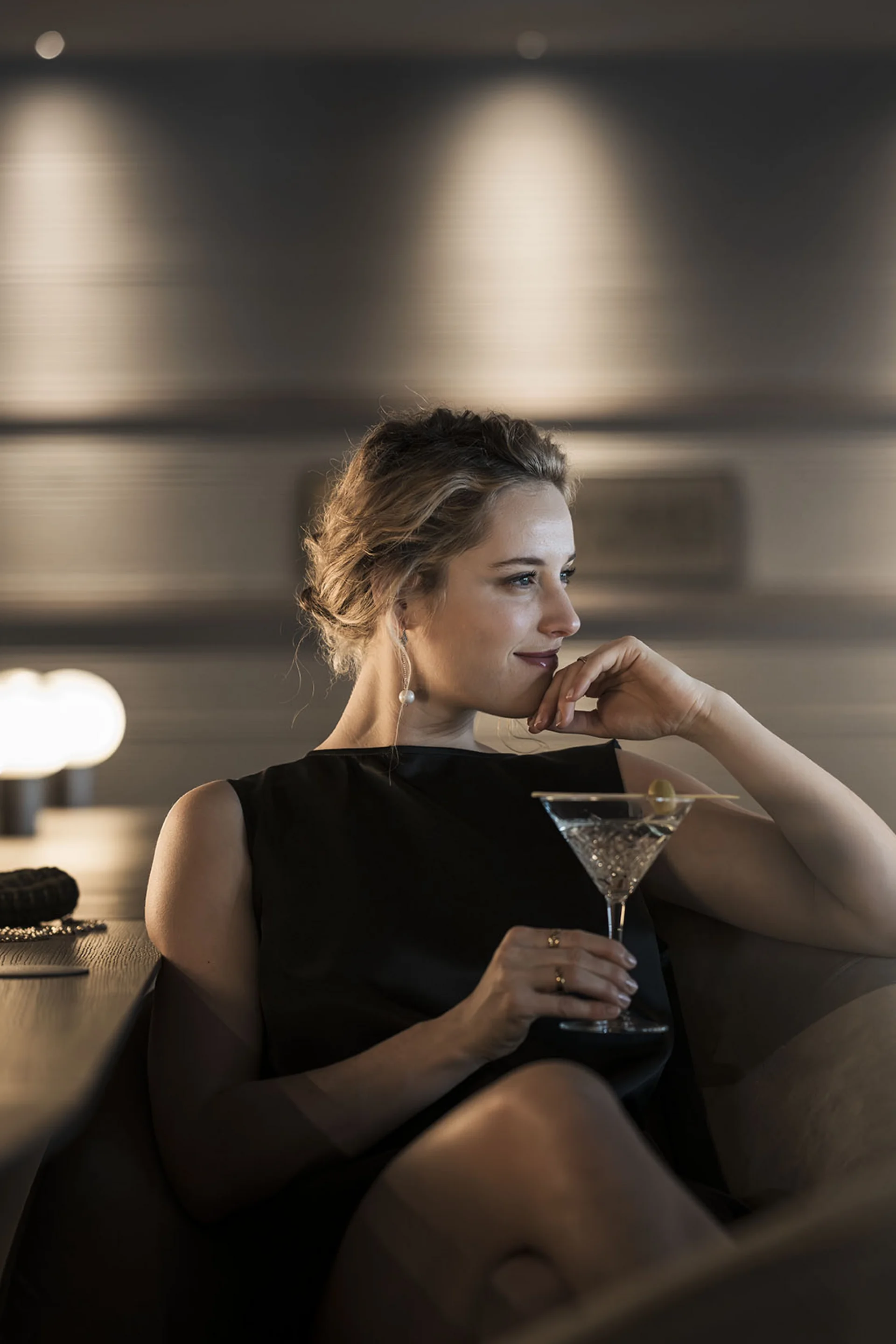 Hotel Monika: eine neue Dimension von Luxus Frau in schwarzem Kleid entspannt mit Cocktail in schicker Bar