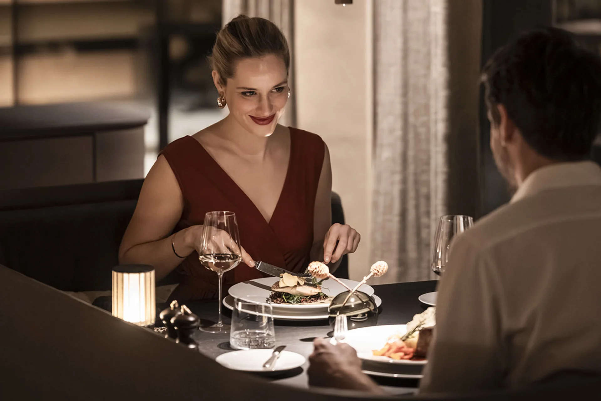 Hotel Monika in Sexten: Wohlbefinden inmitten der Dolomiten Paar beim Abendessen in einem eleganten Restaurant bei gedämpftem Licht