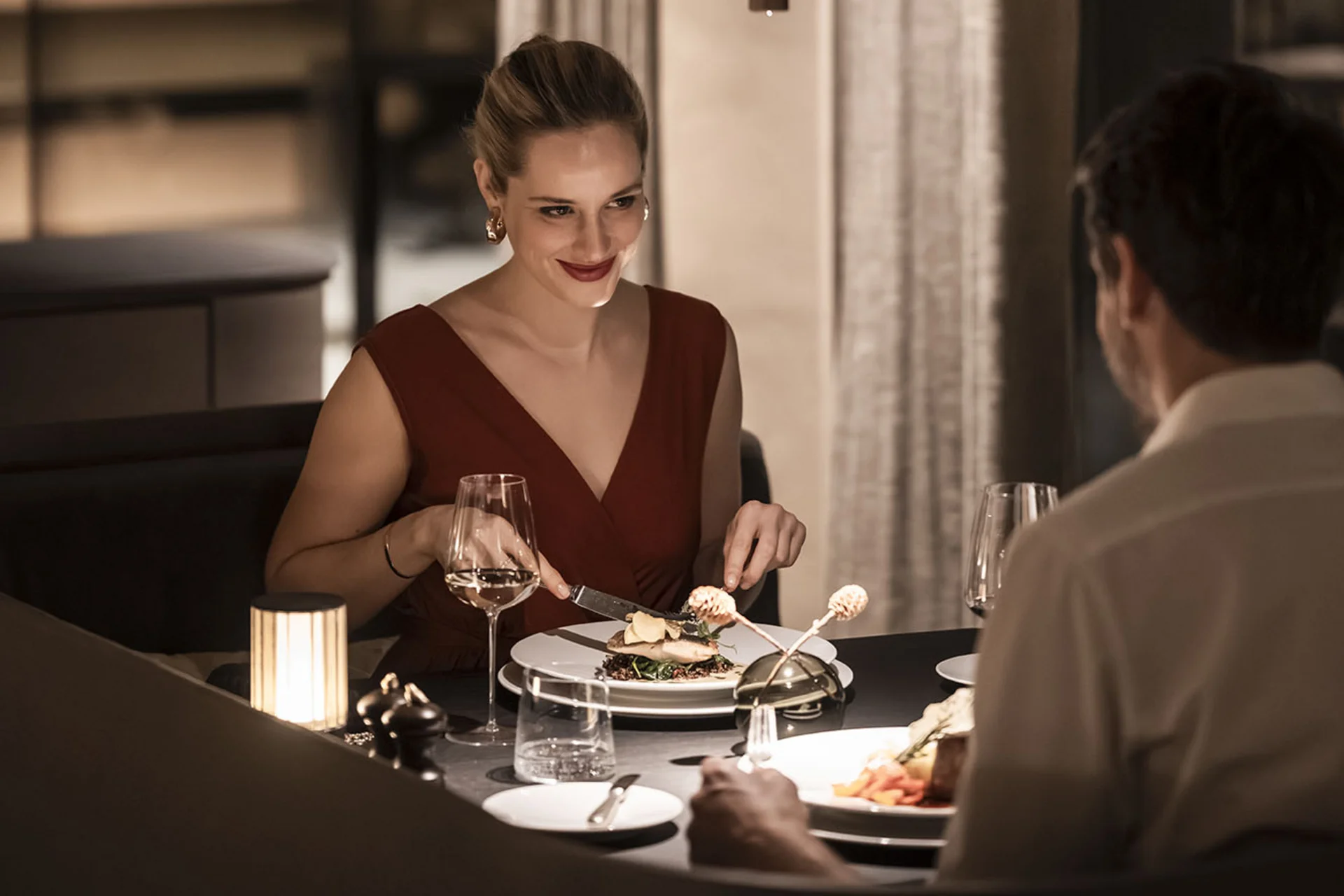 À-la-carte-Restaurant CANA in Sexten Paar beim Abendessen in einem eleganten Restaurant bei gedämpftem Licht