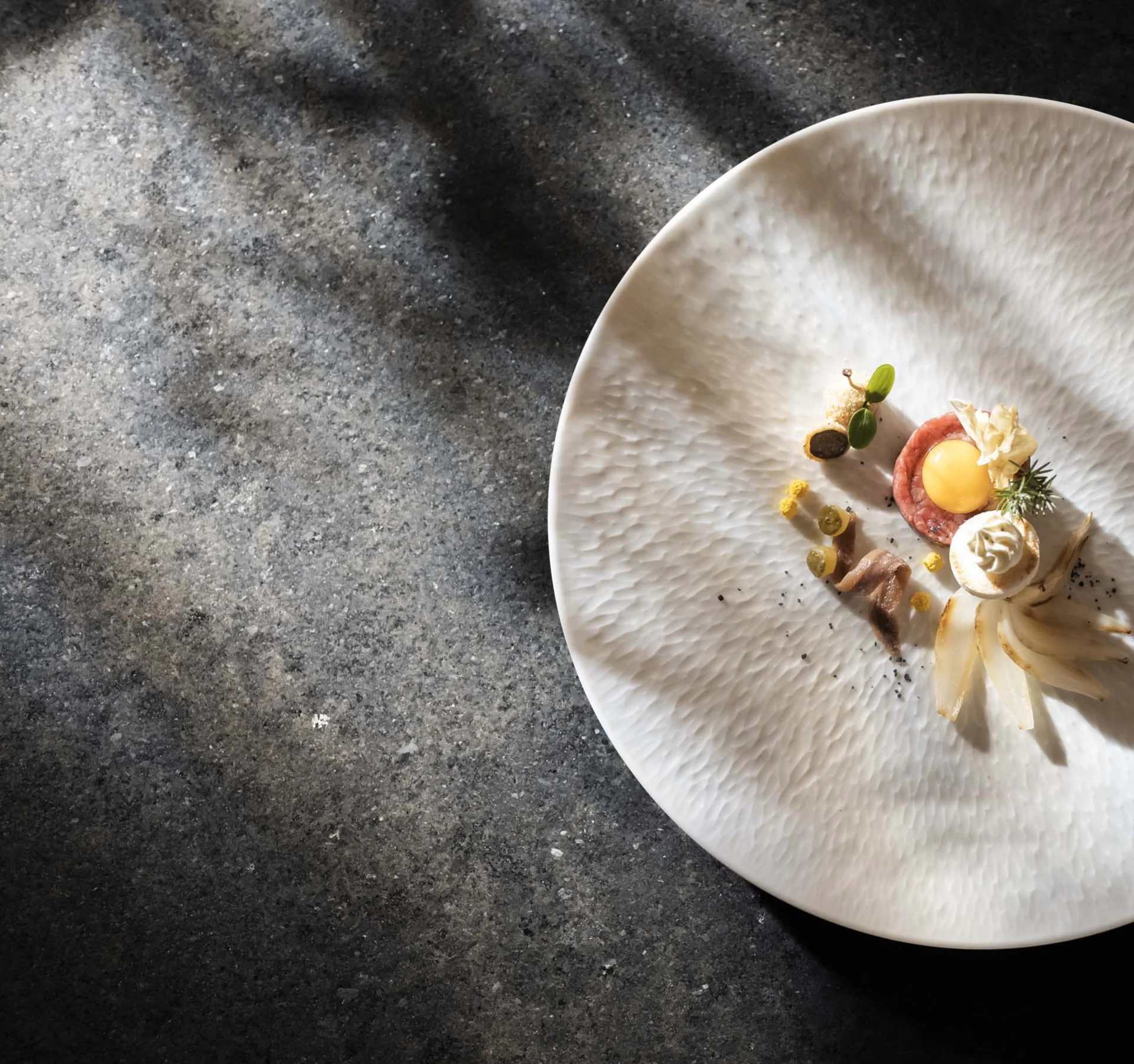 CANA à la carte restaurant in Sexten Artfully plated dish on a white plate with dark background