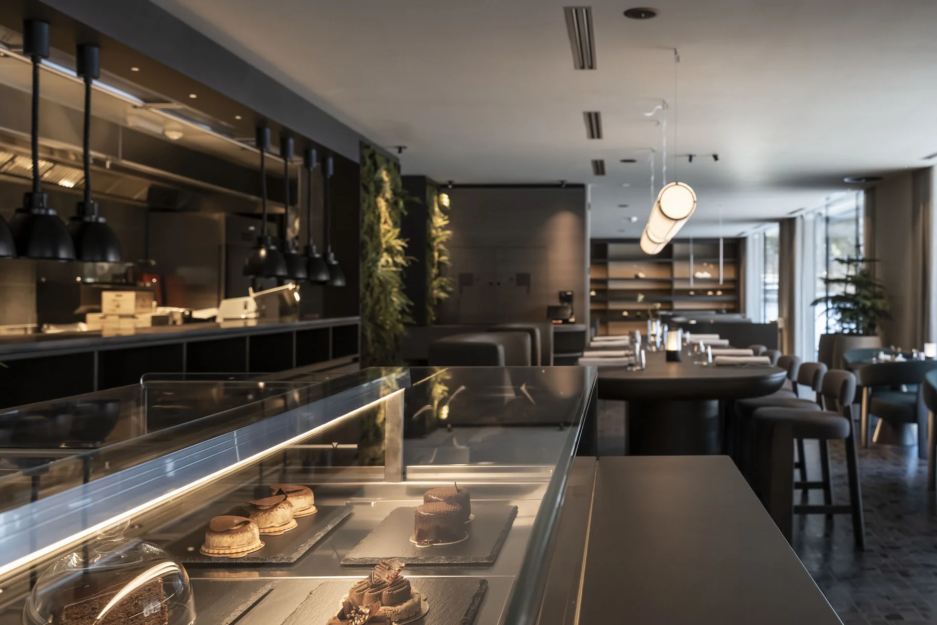 Hotel Monika in Sexten: Wohlbefinden inmitten der Dolomiten Moderne Café-Innenansicht mit Dessertvitrine und Sitzbereich