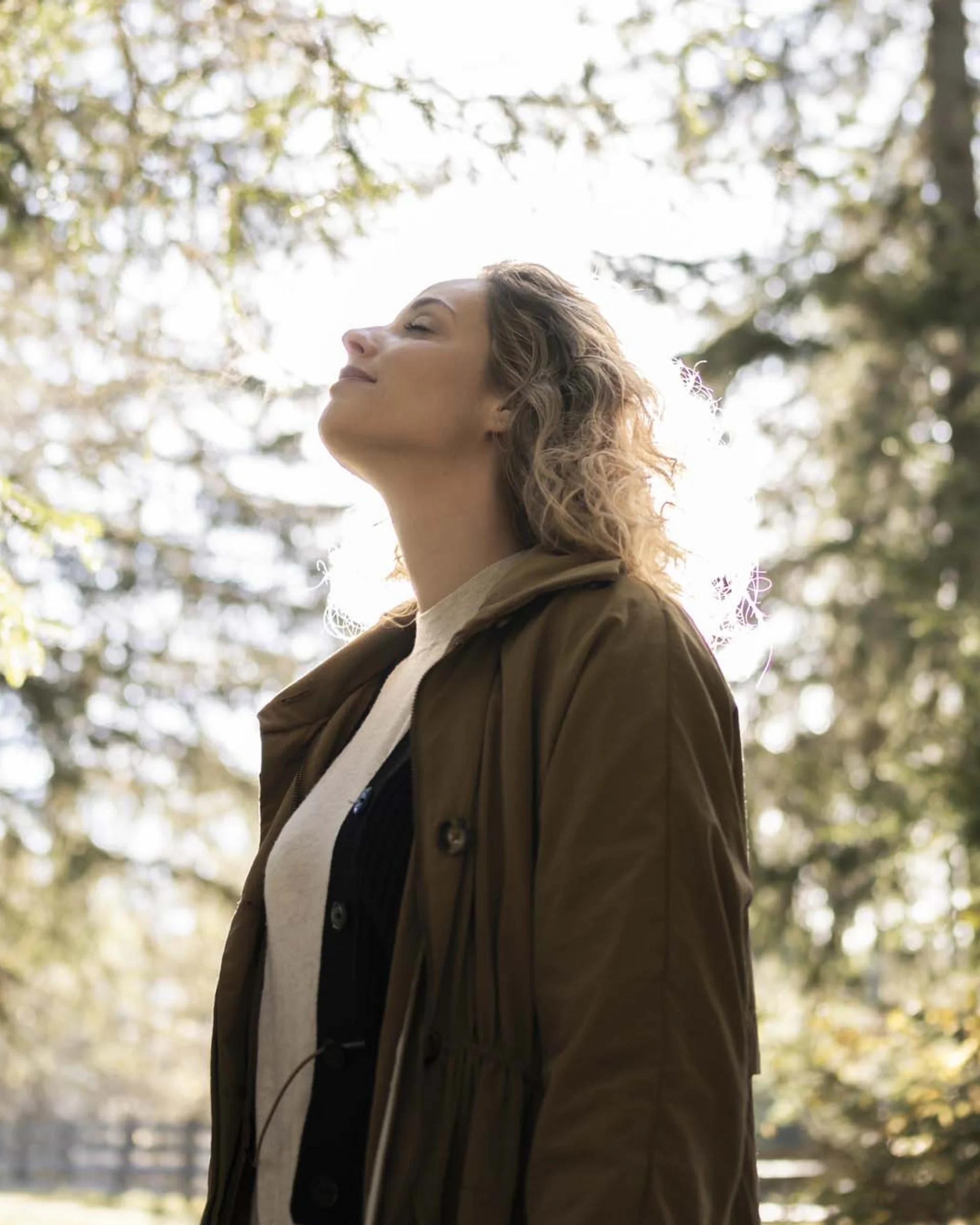 Hotel Monika in Sexten: Wohlbefinden inmitten der Dolomiten Frau genießt die Natur im Wald bei Sonnenlicht