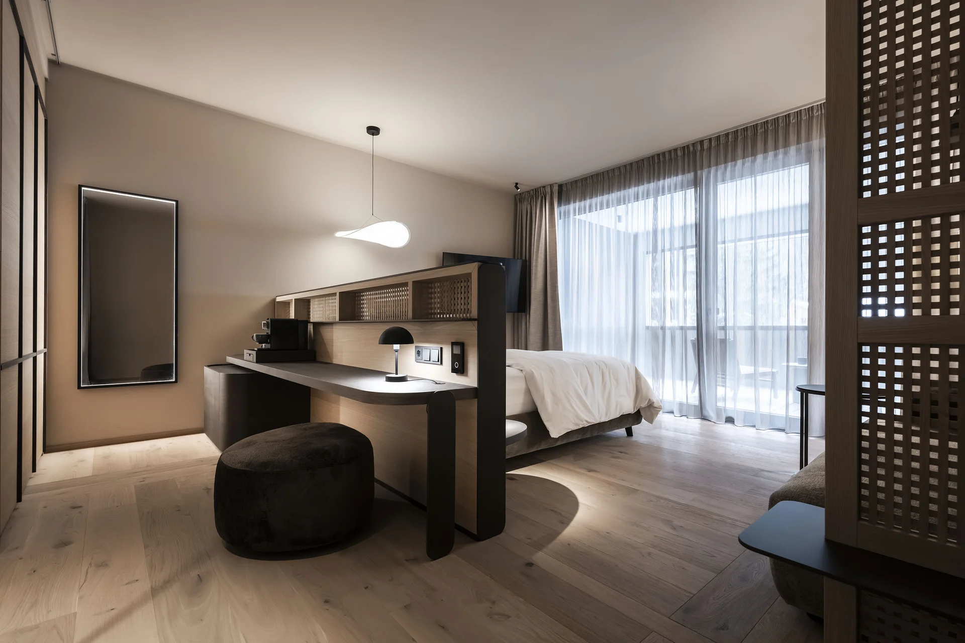 Hotel Monika: das romantische Hotel in Südtirol Modernes Hotelzimmer mit Schreibtisch, Bett und großem Fenster