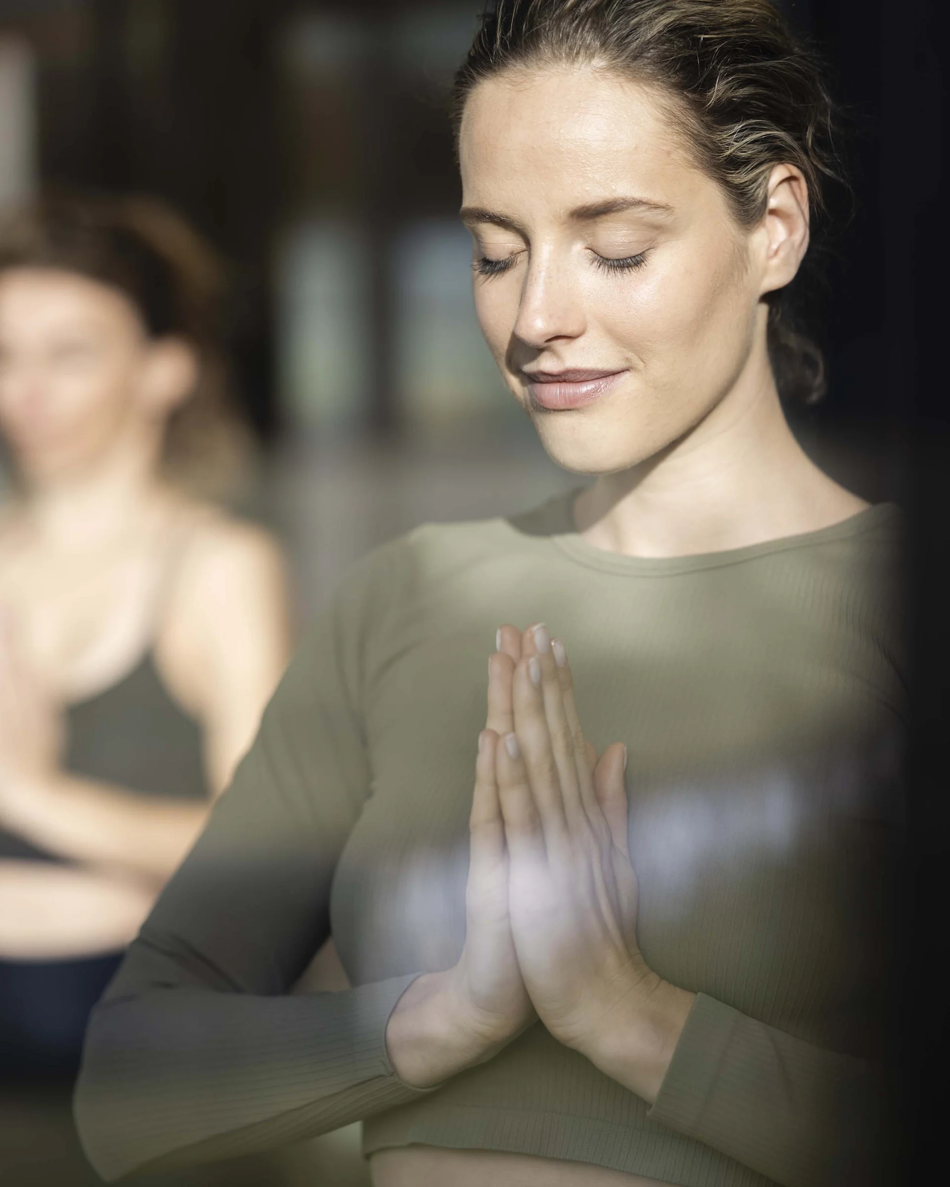 Hotel Monika: soothing day spa in Val Pusteria/Pustertal valley Woman in green clothing meditating with hands together and eyes closed