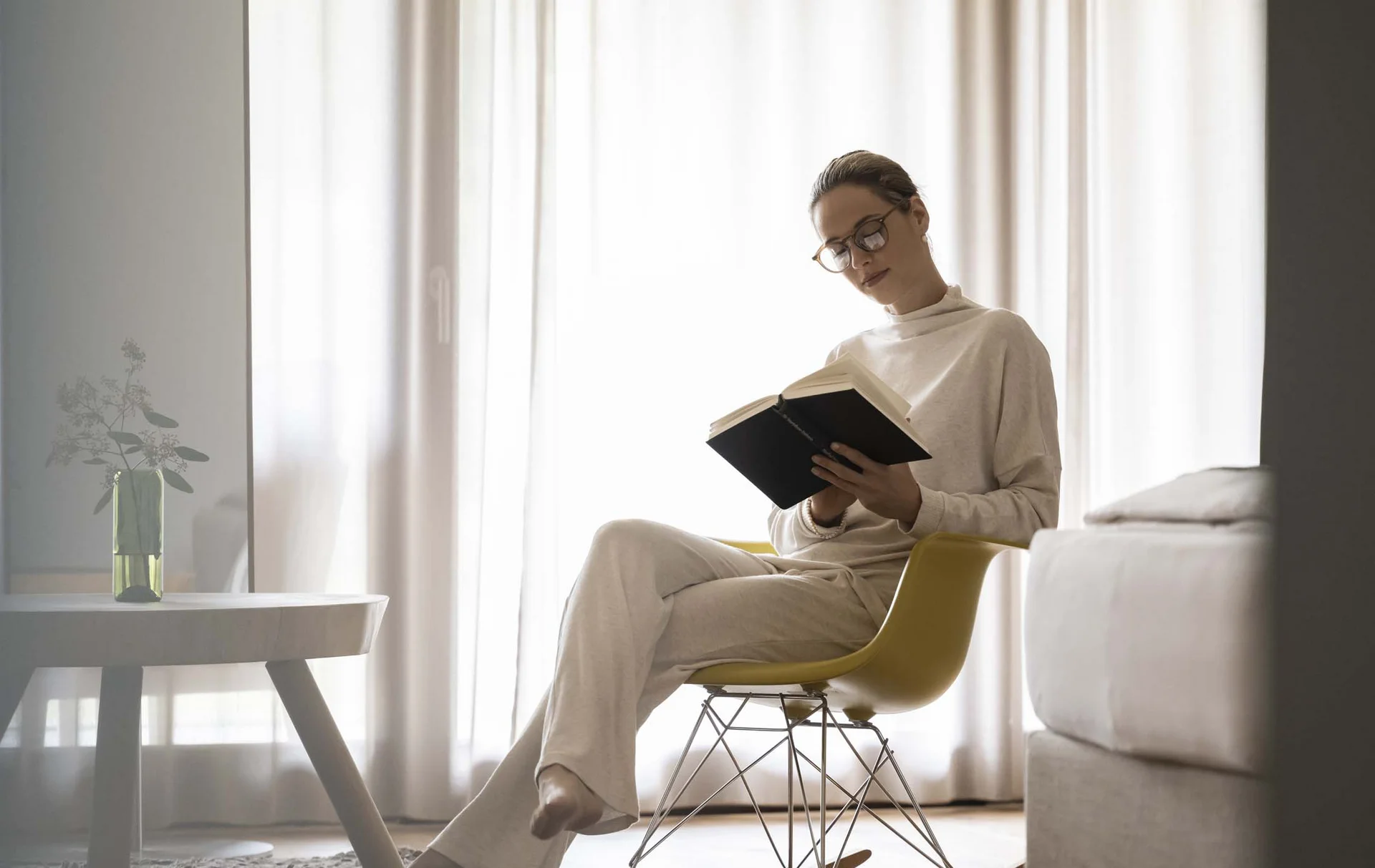 Hotel Monika: a new dimension of luxury Woman reading a book while sitting on a yellow rocking chair in the living room