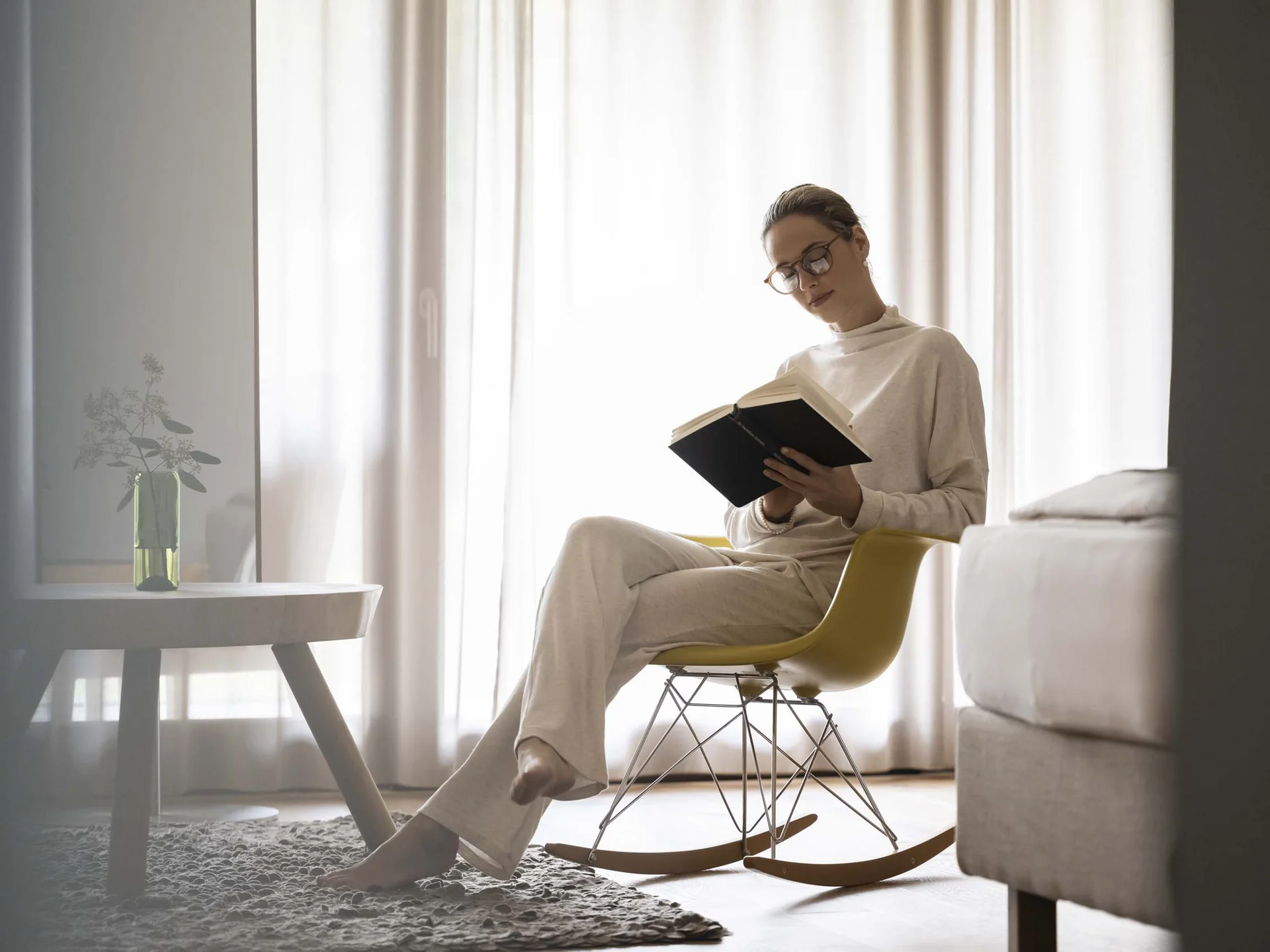 Hotel Monika: your adults-only hotel in South Tyrol Woman reading a book while sitting on a yellow rocking chair in the living room