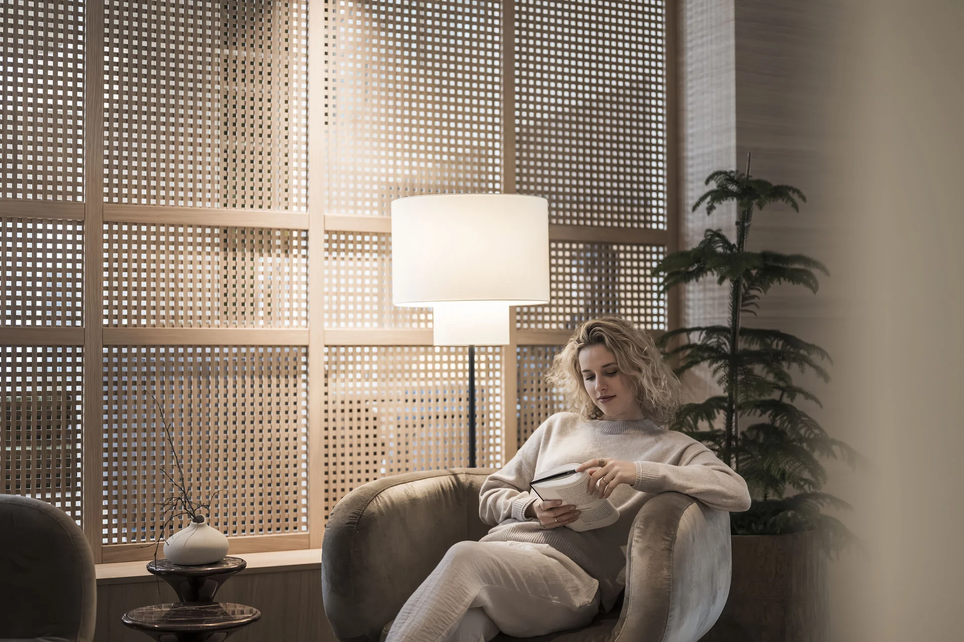 Hotel Monika in Sexten: Wohlbefinden inmitten der Dolomiten Frau liest entspannt Buch in gemütlichem Stuhl bei warmem Licht