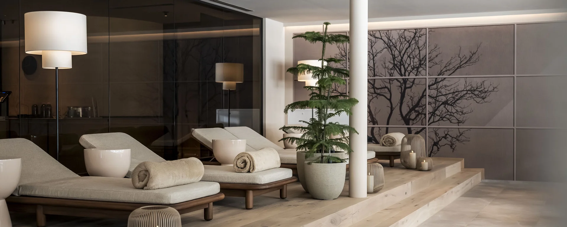 Hotel Monika in Sexten: Wohlbefinden inmitten der Dolomiten Moderne Spa-Lounge mit Liegestühlen, Pflanzen und gedimmter Beleuchtung