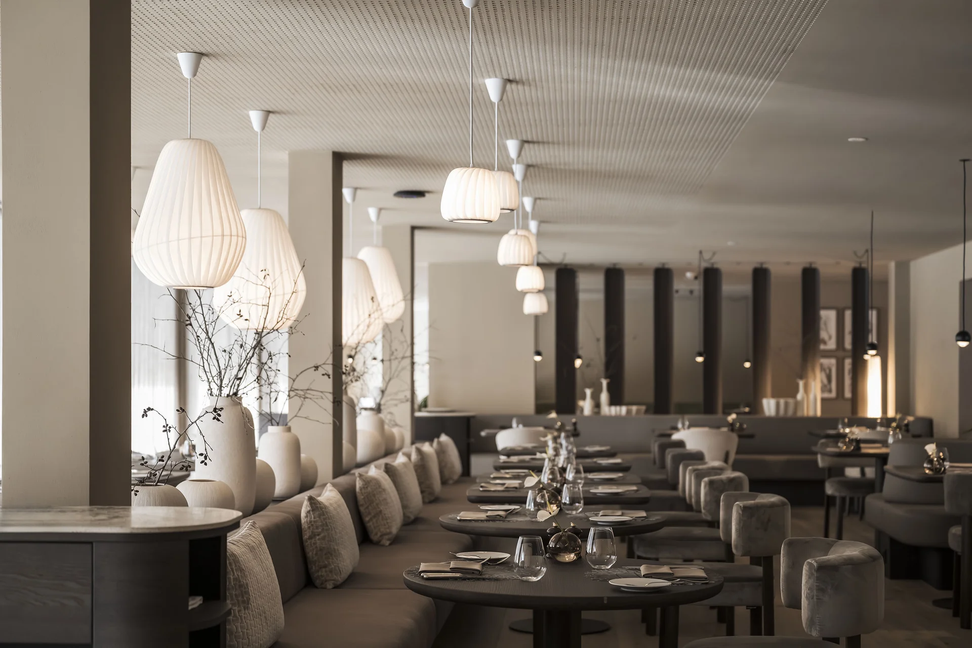 Hotel Monika in Sexten: Wohlbefinden inmitten der Dolomiten Modernes Restaurant mit gedeckten Tischen und stimmungsvoller Beleuchtung