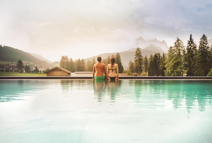Two people enjoy the view from the outdoor pool